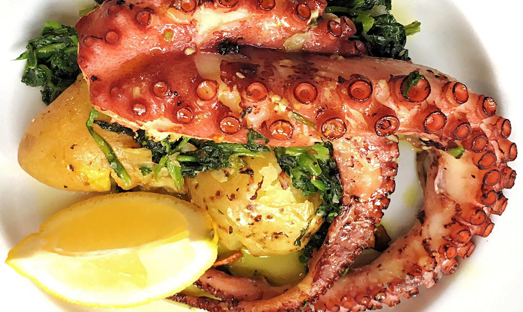 Polvo à Lagareiro: A traditional Portuguese dish featuring tender octopus and smashed potatoes, embodying the flavors of coastal cuisine.