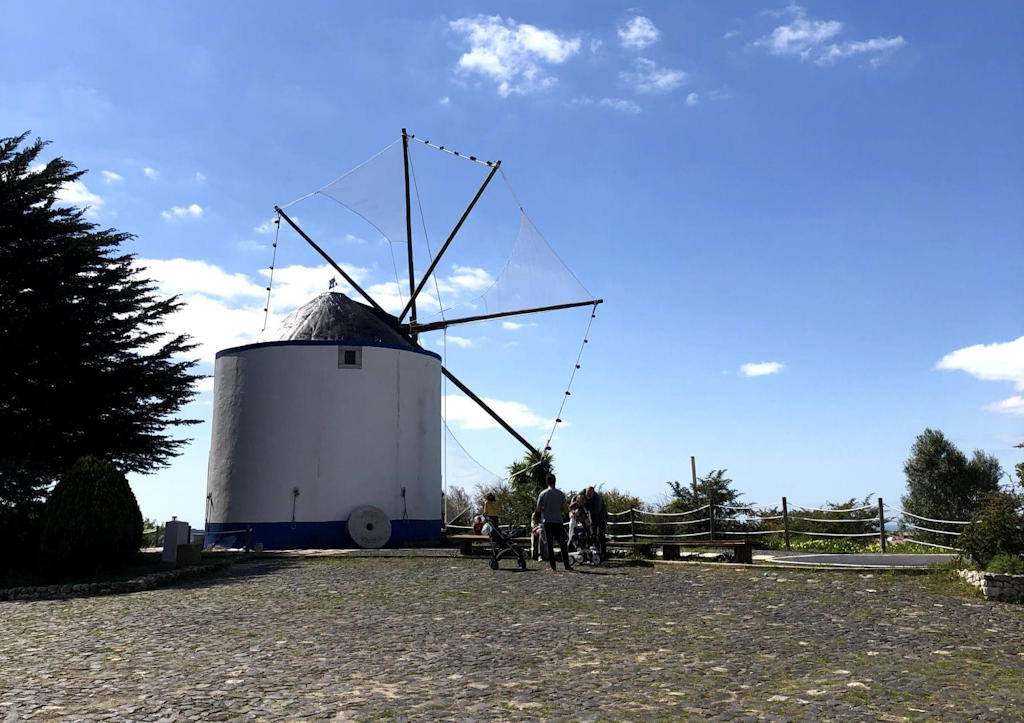 Escape to Parque dos Moinhos de Santana in Lisbon, a serene oasis adorned with windmills, green landscapes, a peaceful lake, and mesmerizing river views.